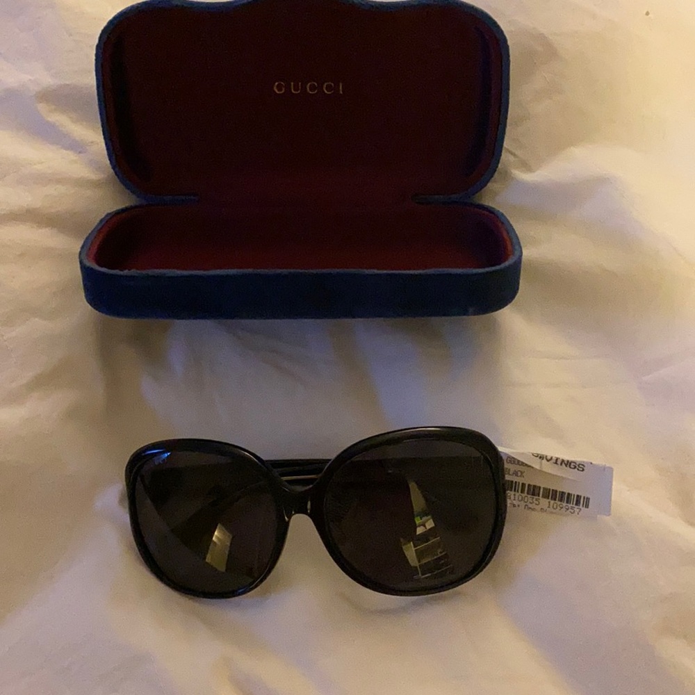 Gucci black sunglasses with gold tags attached